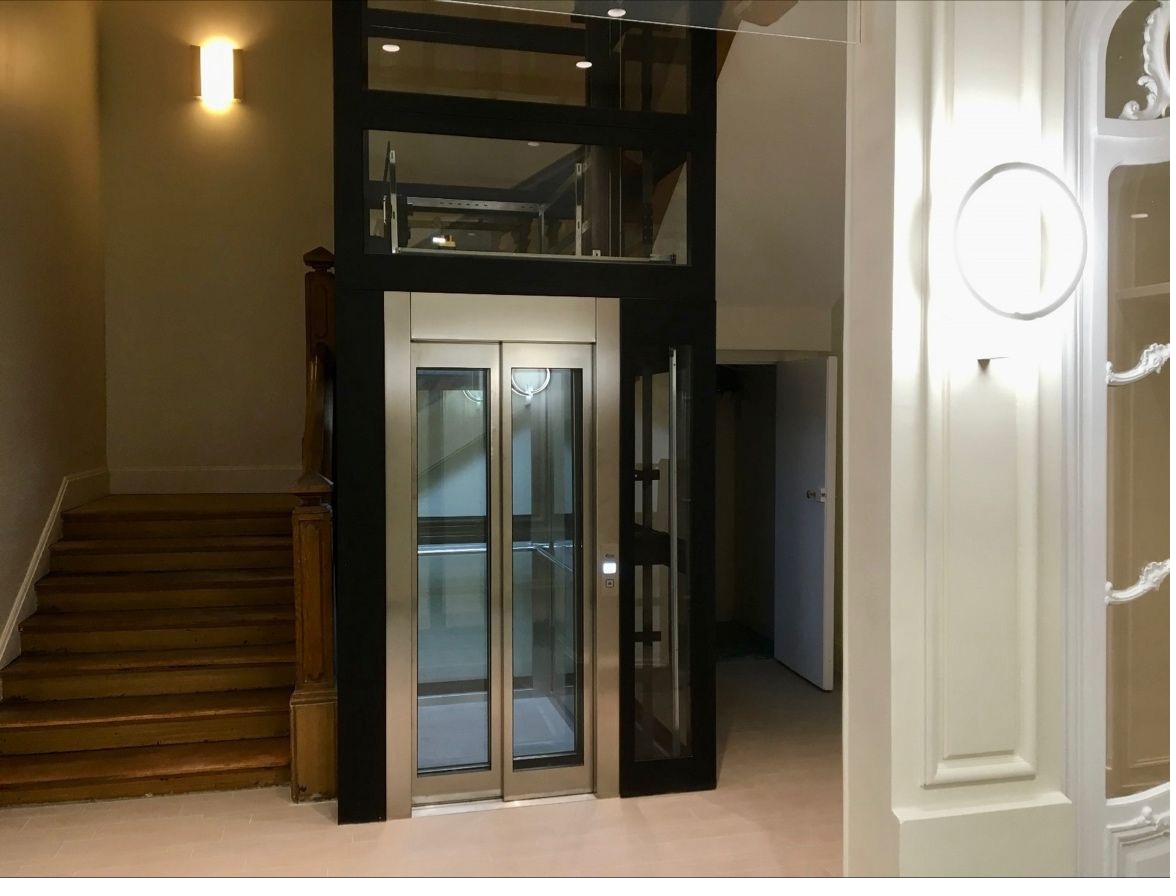 Ascensor con estructura modular y acabado en acero inoxidable integrado en un edificio clásico